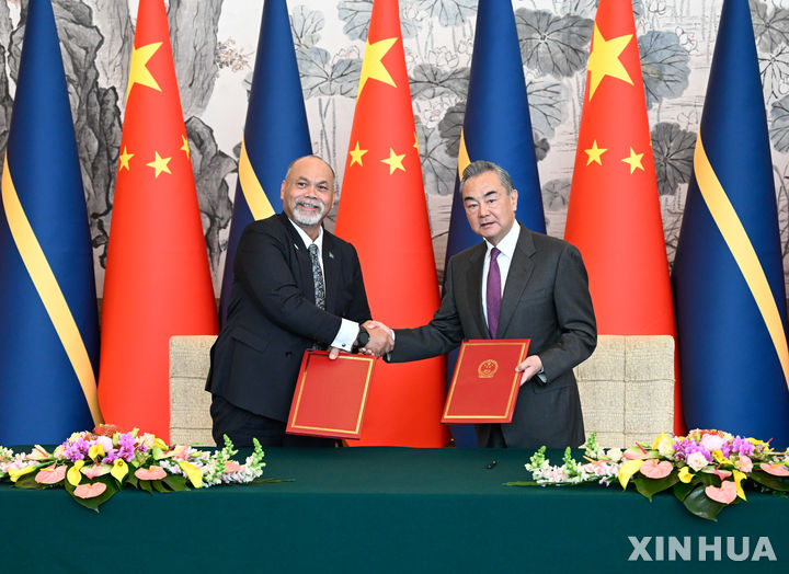 [베이징=신화/뉴시스] 중국 왕이(王毅) 외교부장이 24일 베이징에서 나우루 라이오넬 아인지메아 외무장관과 수교 문서에 서명하고서 교환하고 있다. 2024.01.24 