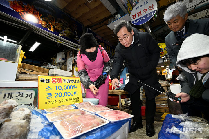 [광주=뉴시스] 이영주 기자 = 이낙연 전 더불어민주당 대표가 24일 오후 광주 동구 남광주시장을 찾아 상인들과 인사하며 물건을 사고 있다. 2024.01.24. leeyj2578@newsis.com