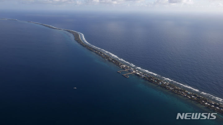 [푸나푸티(투발루)=AP/뉴시스]계속되는 해수면 상승으로 국가가 바닷물 속에 잠길 위기에 처한 투발루 국민의 3분의 1 이상이 호주로 영구 이주할 수 있는 세계 최초의 기후 비자를 신청했다고 BBC가 27일 보도했다. 항공기에서 촬영한 투발루 모습. 2025.06.27.