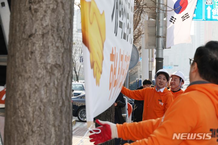 [서울=뉴시스] 조성봉 기자 = 이준석 개혁신당 대표를 비롯한 당직자들이 26일 오후 서울 여의도 국회 앞에서 개혁신당 첫 현수막을 걸고 있다. 2024.01.26. suncho21@newsis.com