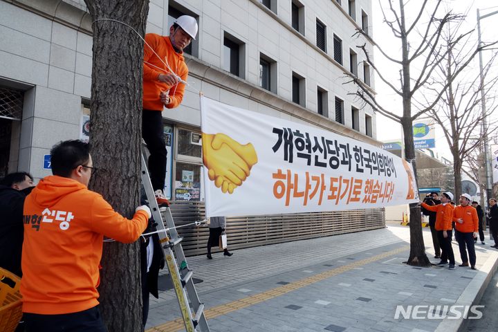 [서울=뉴시스] 조성봉 기자 = 이준석 개혁신당 대표를 비롯한 당직자들이 26일 오후 서울 여의도 국회 앞에서 개혁신당 첫 현수막을 걸고 있다. 2024.01.26. suncho21@newsis.com