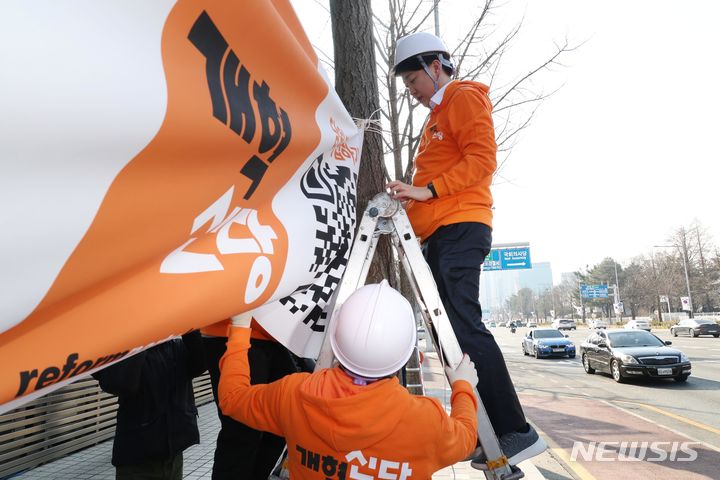 [서울=뉴시스] 조성봉 기자 = 이준석 개혁신당 대표를 비롯한 당직자들이 26일 오후 서울 여의도 국회 앞에서 개혁신당 첫 현수막을 걸고 있다. 2024.01.26. suncho21@newsis.com