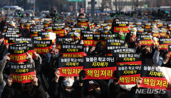 [서울=뉴시스] 고승민 기자 = 초등교사노조 회원들이 지난 27일 서울 경복궁역 인근에서 '교육훼손 정책 및 늘봄학교 규탄' 집회를 열고 구호를 외치는 모습. 2024.01.27. kkssmm99@newsis.com