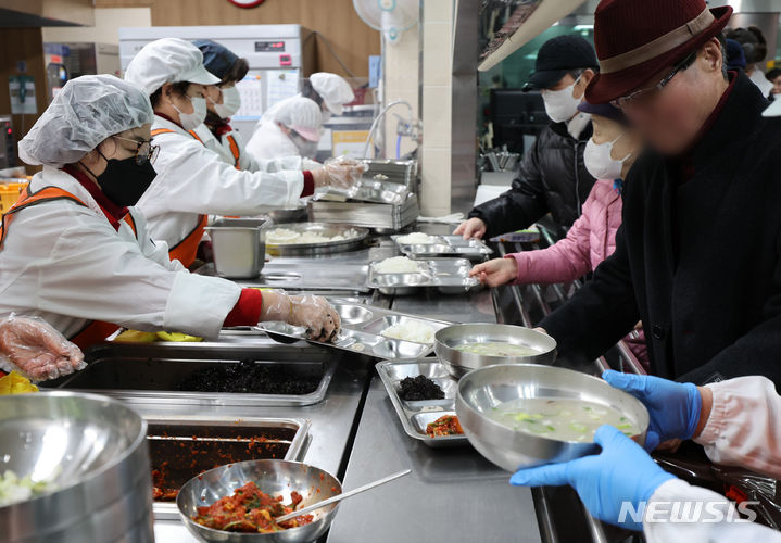 [인천=뉴시스] 전진환 기자 = 30일 오전 설 명절맞이 지역어르신 '건강기원 국밥나눔 행사'가 열린 인천 서구 연희노인문화센터에서 식당에서 어르신들이 배식을 받고 있다. 2024.01.30. amin2@newsis.com