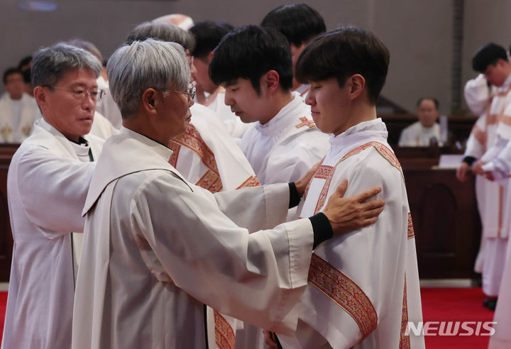 [서울=뉴시스] 사진공동취재단 = 2024년 천주교 서울대교구 부제 서품식이 열린 1일 서울 중구 명동대성당에서 추천 사제들이 부제 수품자들에게 달마티카(부제복)를 입혀주고 있다. 2024.02.01. photo@newsis.com
