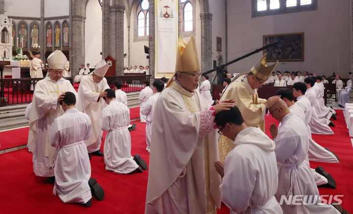 [서울=뉴시스] 사진공동취재단 = 1일 서울 중구 명동대성당에서 열린 2024년 천주교 서울대교구 부제 서품식에서 부제 수품자들이 정순택 대주교를 비롯한 교구 주교·사제단에게 안수받고 있다. 2024.02.01. photo@newsis.com