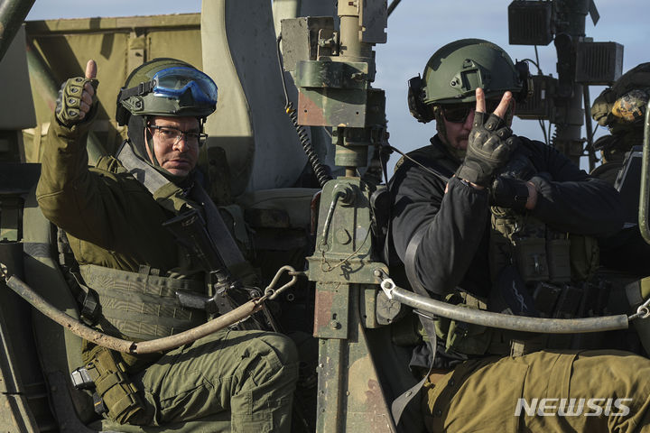 [가자지구=AP/뉴시스] 2월1일 가자지구에서 이스라엘 남부로 돌아오는 이스라엘 군인들이 차 안에서 취재진의 카메라를 향해 손을 흔들고 있다. 가자 북부의 이스라엘군이 철수했다고 목격자들은 전했다. 2024.02.02.