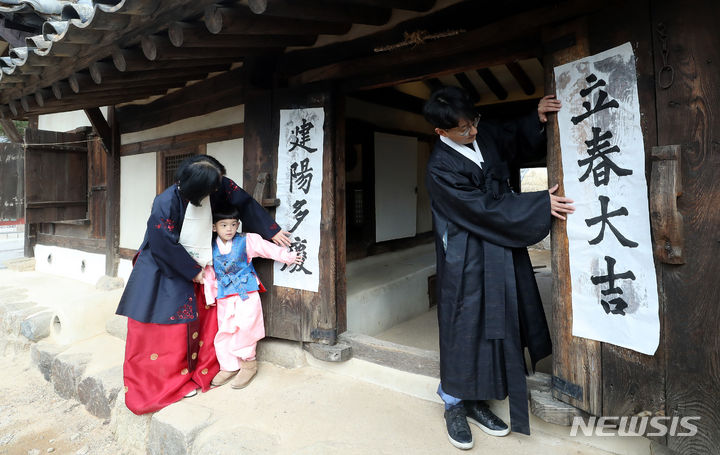 [서울=뉴시스] 김혜진 기자 = 입춘을 이틀 앞둔 2일 오전 서울 종로구 국립민속박물관 오촌댁에서 열린 입춘 세시행사에서 박진우 서예가 등이 '입춘대길(立春大吉) 건양다경(建陽多慶)' 입춘첩을 붙이고 있다. 2024.02.02. jini@newsis.com