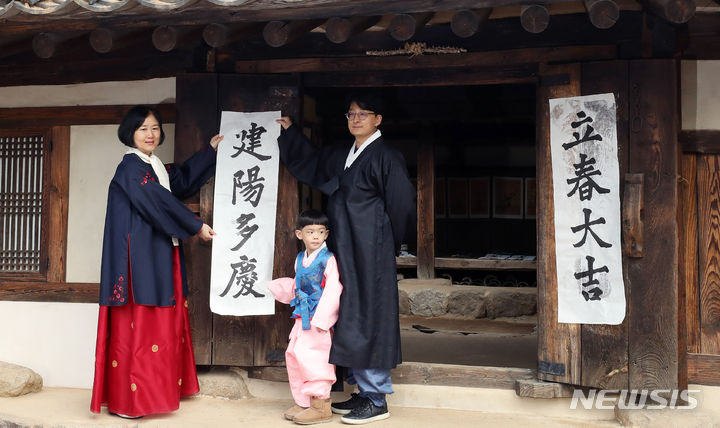 [서울=뉴시스] 김혜진 기자 = 입춘을 이틀 앞둔 2일 오전 서울 종로구 국립민속박물관 오촌댁에서 열린 입춘 세시행사에서 박진우 서예가 등이 '입춘대길(立春大吉) 건양다경(建陽多慶)' 입춘첩을 붙이고 있다. 2024.02.02. jini@newsis.com