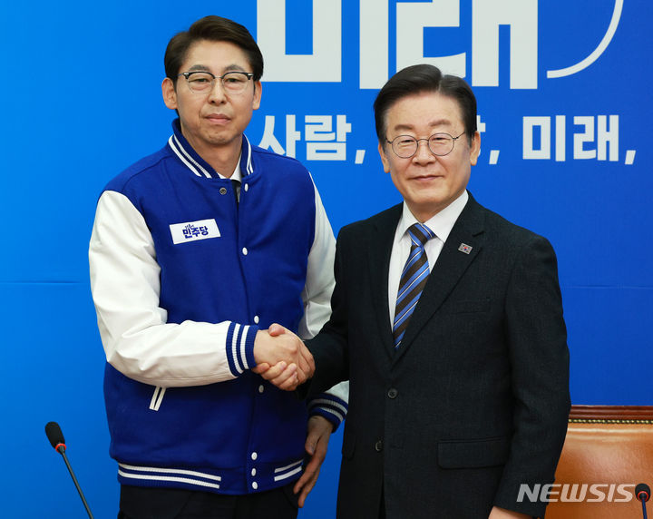 [서울=뉴시스] 고범준 기자 = 이재명 더불어민주당 대표가 2일 오전 서울 여의도 국회에서 열린 13·14차 인재영입식에서 이훈기 전 기자에게 당 점퍼를 선물하고 기념촬영을 하고 있다. 2024.02.02. bjko@newsis.com