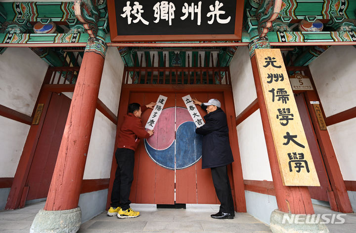 [광주=뉴시스] 이영주 기자 = 24절기의 첫 번째인 입춘을 이틀 앞둔 2일 광주 남구 광주향교에서 향교 관계자들이 입춘첩을 붙이고 있다. '입춘대길 건양다경(立春大吉 建陽多慶)'은 '봄이 시작되니 크게 길하고 경사스러운 일이 많이 생기길 기원한다'는 의미를 갖고 있다. 2024.02.02. leeyj2578@newsis.com