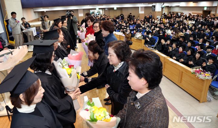 [부산=뉴시스] 하경민 기자 = 2일 부산 사하구 은항교회에서 열린 부산 부경보건고등학교와 병설 부경중학교 졸업식에 참석한 만학도 졸업생들이 후배들의 축하 꽃다발을 받고 있다. 이날 졸업식에는 배움의 끈을 놓쳤던 40~80대 늦깎이 중·고교생 418명(중학교 21회 202명, 고등학교 22회 216명)이 꿈에 그리던 졸업장을 품에 안았다. 2024.02.02. yulnetphoto@newsis.com