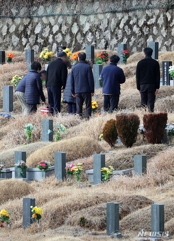 [부산=뉴시스] 하경민 기자 = 설 연휴를 닷새 앞둔 4일 부산 금정구 영락공원을 찾은 한 가족이 미리 조상묘를 찾아 인사를 올리고 있다. 2024.02.04. yulnetphoto@newsis.com