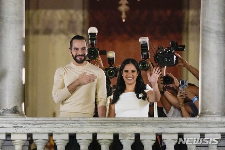 [산살바도르=AP/뉴시스] 나이브 부켈레(왼쪽) 엘살바도르 대통령이 올해 2월 4일 대선 결과 재선에 성공하면서 부인 가브리엘라 로드리게스 여사와 함께 산살바도르의 국립궁전 2층 발코니에 나와 환호하는 지지자들에게 인사하고 있다. 그는 8월 29일자 타임지 인터뷰에서 갱단과의 전쟁을 위한 비상사태 연장을 곧 끝낼 것이라고 밝혔다. 2024.08.30.