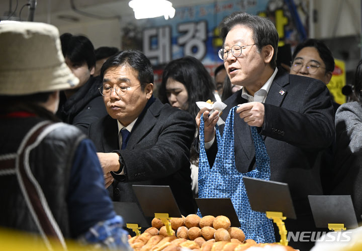[광주=뉴시스] 박기웅 기자 = 이재명 더불어민주당 대표가 5일 오후 설 명절을 앞두고 광주 서구 양동시장을 방문해 한 상가에서 찹쌀도너츠를 구입하고 있다. 2024.02.05. pboxer@newsis.com