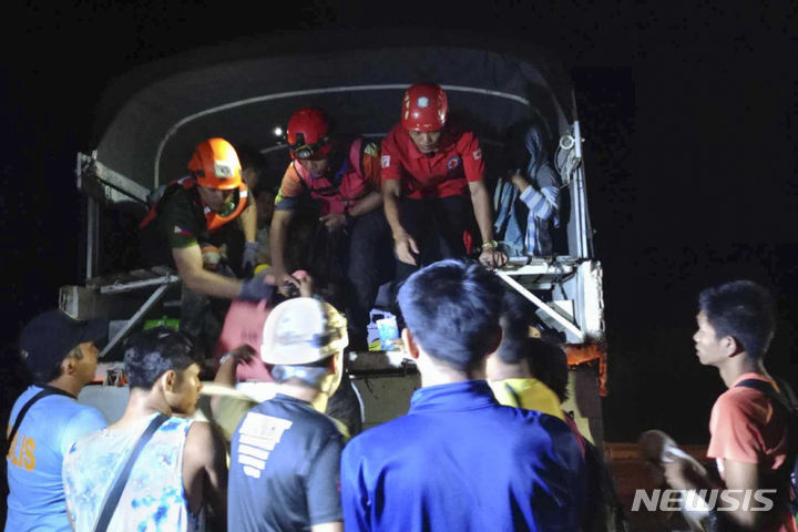 [AP/뉴시스] 필리핀 적십자사 제공 사진으로 7일 새벽 남부 다바오 데 오로주 산사태 현장에서 구조 요원들이 주민 대피를 돕고 있다 