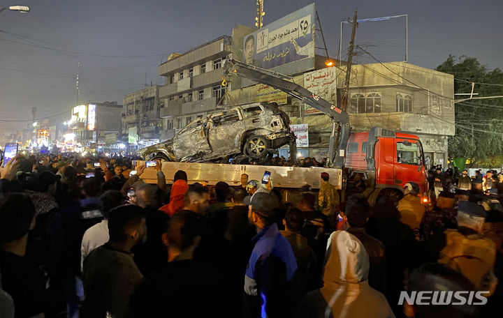 [바그다드=AP/뉴시스] 미국이 7일(현지시간) 요르단 주둔 자국군 병사 사망에 대한 보복으로 바그다드를 공습해 카타이브 헤즈볼라 고위 지휘관이 사망한 가운데 이라크는이번 공습이 미국의 침략 행위라고 반발했다. 사진은 이날 이라크 수도 바그다드에서 이라크 사람들이 미군의 드론 공격으로 불에 탄 차량 주변에 모여 있는 모습.  2024.02.08.