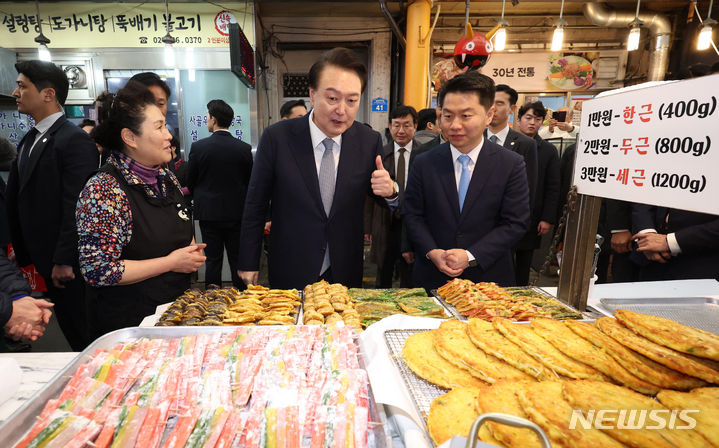 [서울=뉴시스] 조수정 기자 = 윤석열 대통령이 설 연휴를 하루 앞둔 8일 서울 광진구 중곡제일시장을 방문해 전집 상인과 대화하며 엄지를 치켜세우고 있다. 2024.02.08. chocrystal@newsis.com