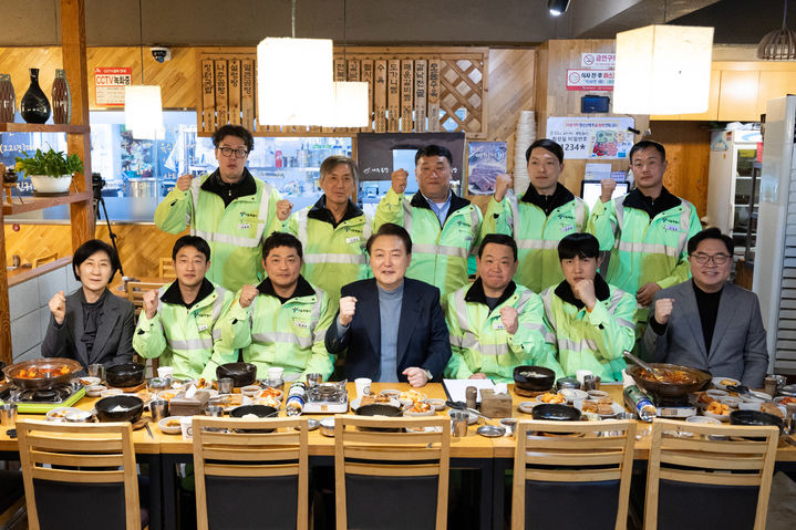 [서울=뉴시스] 윤석열 대통령이 설 연휴 첫날인 9일 서울 동작구 한 식당에서 환경공무관들과 만나 기념촬영하고 있다. (사진=대통령실 제공) 2024.02.09. photo@newsis.com *재판매 및 DB 금지