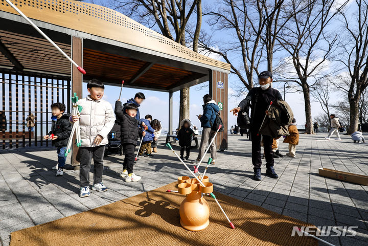 [서울=뉴시스] 정병혁 기자 = 설 연휴 첫날인 9일 서울 중구 남산공원을 찾은 시민들이 투호, 윷놀이, 제기차기 등 전통놀이를 즐기고 있다. 2024.02.09. jhope@newsis.com