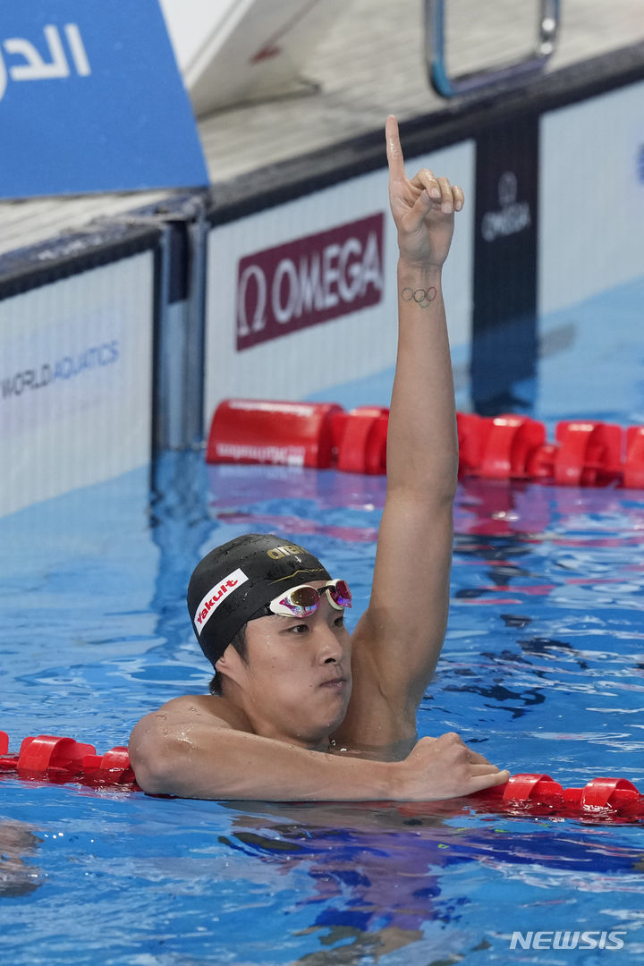 [도하=AP/뉴시스] 김우민이 12일(한국시간) 카타르 도하 어스파이어돔에서 열린 2024 국제수영연맹 세계선수권대회 남자 자유형 400m 결승에서 342초71을 기록, 금메달을 따낸 뒤 세리머니를 하고 있다. 2024.02.12