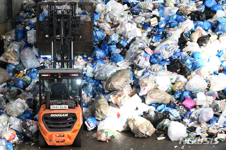 [광주=뉴시스] 이영주 기자 = 13일 오전 광주 북구 월출동 한 재활용품 선별장에서 지게차가 설 연휴 당시 배출된 쓰레기들을 모으고 있다. 2024.02.13 leeyj2578@newsis.com