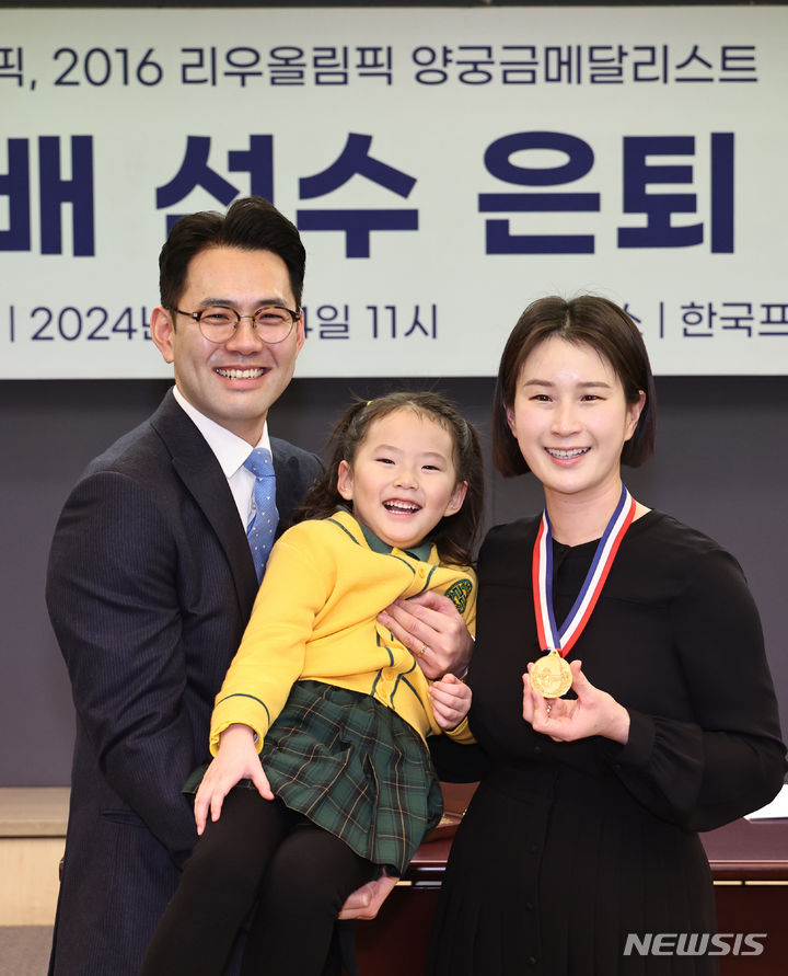 [서울=뉴시스] 김금보 기자 = 올림픽 양궁 금메달리스트 기보배가 14일 오전 서울 중구 한국프레스센터에서 열린 은퇴 기자회견에서 가족에게 27돈 금메달 은퇴선물을 받고 기념촬영을 하고 있다. 2024.02.14. kgb@newsis.com