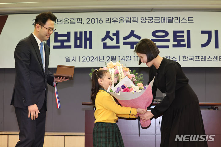 [서울=뉴시스] 김금보 기자 = 올림픽 양궁 금메달리스트 기보배가 14일 오전 서울 중구 한국프레스센터에서 열린 은퇴 기자회견에서 가족에게 27돈 금메달 은퇴선물을 전달받고 있다. 2024.02.14. kgb@newsis.com