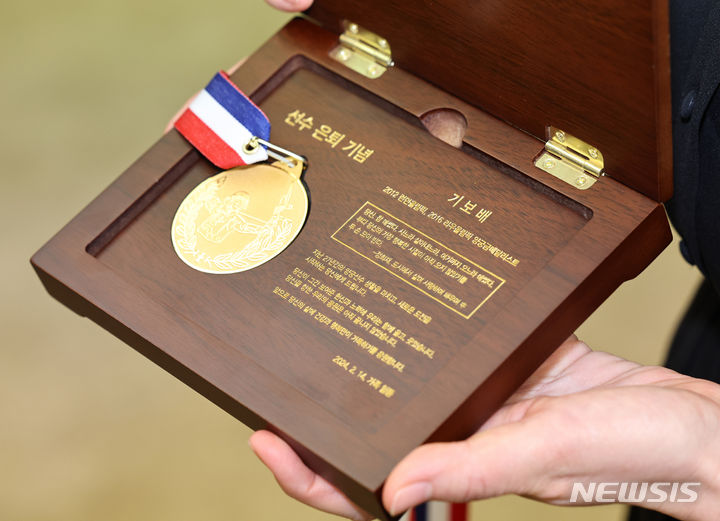 [서울=뉴시스] 김금보 기자 = 올림픽 양궁 금메달리스트 기보배가 14일 오전 서울 중구 한국프레스센터에서 열린 은퇴 기자회견에서 가족에게 받은 27돈 금메달 은퇴선물을 보여주고 있다. 2024.02.14. kgb@newsis.com