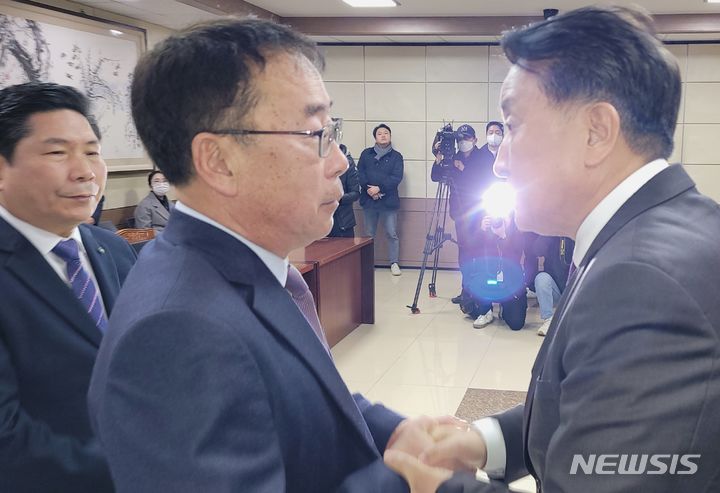 [제천=뉴시스] 이병찬 기자 = 충북 제천 스포츠센터 화재 참사 유족 류건덕 대표와 김영환(오른쪽) 충북지사가 15일 제천시청에서 유족 지원에 관한 협약을 한 뒤 악수하고 있다. 사진 왼쪽은 김창규 제천시장.2024.02.15.bclee@newsis.com 