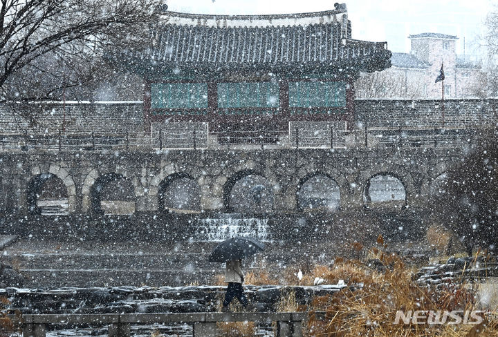 [수원=뉴시스] 김종택 기자 = 15일 경기도 수원시 팔달구 화홍문에서 시민들이 눈을 맞으며 걷고 있다. 2024.02.15. jtk@newsis.com