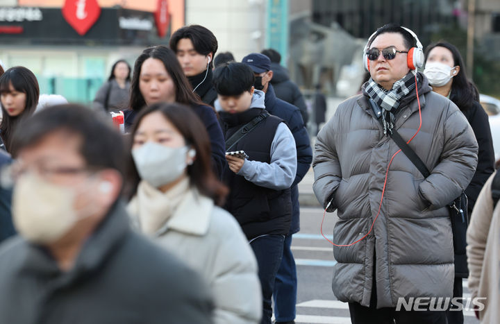 [서울=뉴시스] 황준선 기자 = 지난 16일 오전 서울 종로구 세종대로 사거리에서 한 시민이 헤드셋을 착용한 채 길을 건너고 있다. 다른 시민들도 무선이어폰을 낀 채 휴대전화를 이용하며 횡단보도를 건너고 있다. 2024.02.16. hwang@newsis.com