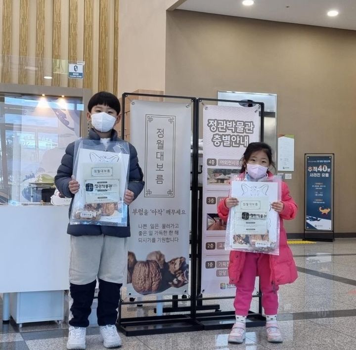 [부산=뉴시스] 부산 정관박물관에서 진행된 '2023 부럼 꾸러미 나눔 행사'에서 아이들이 기념 사진을 촬영하고 있다. (사진=부산시 제공) 2023.02.05. photo@newsis.com *재판매 및 DB 금지