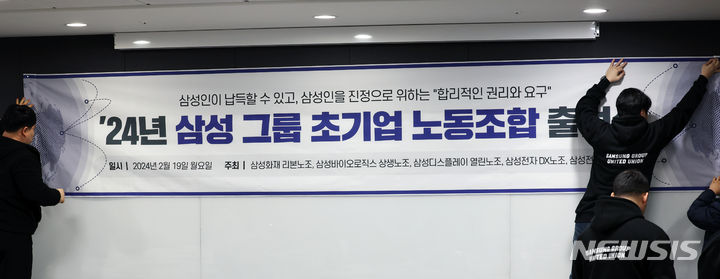 [서울=뉴시스] 고승민 기자 = 19일 서울 서초구 한국컨퍼런스센터에서 삼성그룹 초기업 노조 출범 기자회견이 열리기 전 참석자들이 기자회견 현수막을 걸고 있다. 2024.02.19. kkssmm99@newsis.com