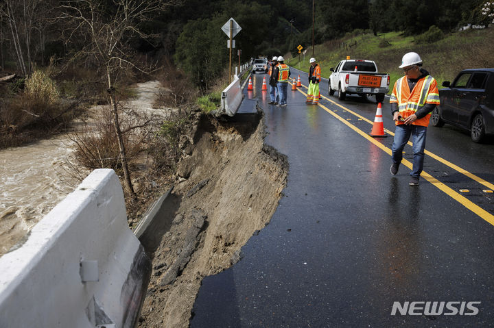 [수놀=AP/뉴시스] 19일(현지시각) 미 캘리포니아주 수놀에서 인부들이 폭풍우로 유실된 도로를 보수하고 있다. 캘리포니아 대기 상층을 덮은 강력한 저기압이 아열대성 폭우와 강풍을 일으켜 곳곳에 폭우가 내렸고 21일까지 비가 이어질 것으로 예보됐다. 2024.02.20.