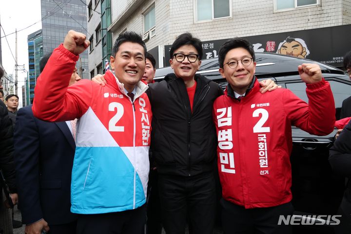 [서울=뉴시스] 조성봉 기자= 한동훈 국민의힘 비상대책위원장이 20일 오후 서울 광진구 화양동에서 '시민이 안전한 대한민국' 현장 공약 발표를 하기 위해 이동하기 전 단수공천을 받은 오신환(왼쪽) 광진을 후보, 김병민 광진 갑 후보와 함께 손을 들고 있다.2024.02.20. suncho21@newsis.com