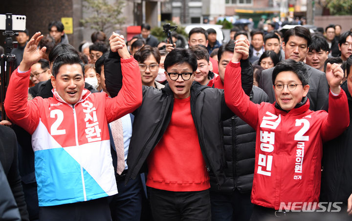 [서울=뉴시스] 조성봉 기자= 한동훈 국민의힘 비상대책위원장이 20일 서울 광진구 화양동에서 '시민이 안전한 대한민국' 현장 공약을 발표하기 위해 이동하며 단수공천을 받은 김병민 광진 갑 후보, 오신환 광진을 후보와 함께 손을 들고 있다.(공동취재)2024.02.20. photo@newsis.com