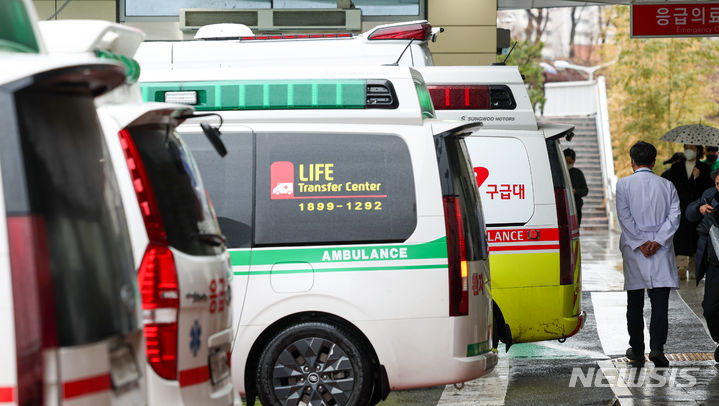 [서울=뉴시스] 김명년 기자 = 21일 오후 서울 시내 한 대학병원에서 의료진이 줄지어 선 구급차를 지나가고 있다. 2024.02.21. kmn@newsis.com