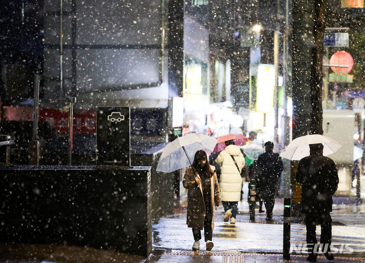 [서울=뉴시스] 김선웅 기자 = 서울 등 수도권 일부 지역에 대설 예비특보가 내려진 21일 저녁 서울 중구 퇴계로에서 우산을 쓴 시민들이 내리는 눈 사이를 걷고 있다. 2024.02.21. mangusta@newsis.com