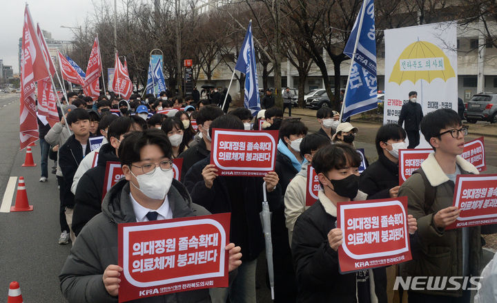 [전주=뉴시스] 김얼 기자 = 전북대학교와 원광대학교 의대생들이 지난 22일 전북 전주시 전주종합경기장 앞 도로에서 열린 '의대정원증원 필수의료패키지 저지를 위한 궐기대회'에 참석해 손피켓을 들고 구호를 외치고 있다. 2024.02.22. pmkeul@newsis.com