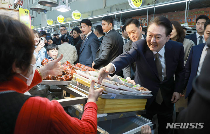 [창원=뉴시스] 전신 기자 = 윤석열 대통령이 22일 경남 창원 마산어시장을 방문해 족발집 상인과 인사하고 있다. (대통령실통신사진기자단) 2024.02.22. photo1006@newsis.com