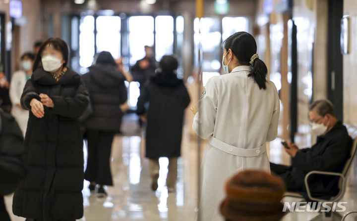 [서울=뉴시스] 정병혁 기자 = 전공의 업무중단이 이어지고 있는 23일 서울의 한 대학병원에서 의료진이 이동하고 있다. 정부는 이날 전공의 이탈에 따른 국민 건강·생명 피해 우려가 크다고 보고 역대 처음으로 보건의료재난 경보 단계를 최고 수준인 '심각'으로 격상했다. 이에 따라 정부는 현장의 의료 공백을 해소하기 위해 비대면진료를 무기한 전면 허용하기로 했다. 2024.02.23. jhope@newsis.com