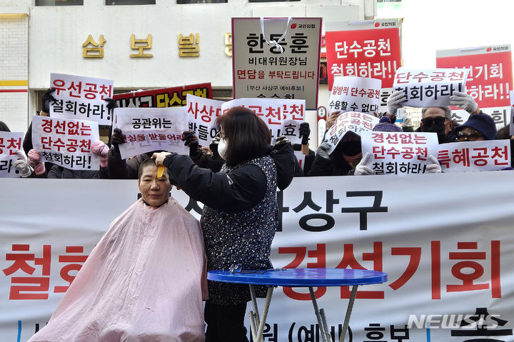 [서울=뉴시스] 한은진 기자= 23일 오후 서울 여의도 국민의힘 중앙당사 앞에서 부산 사상구 불공정 단수공천 철회촉구하며 송숙희 예비후보가 삭발을 하고 있다.2024.02.23. gold@newsis.com