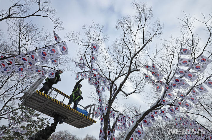 [서울=뉴시스] 김금보 기자 = 23일 오전 서울 용산구 효창공원 일대에서 작업자들이 가로수에 태극기를 게양하고 있다. 용산구는 다음달 3일까지 효창공원 일대 710m 구간을 '제105주년 3.1절 기념 태극기 거리'로 조성한다. 2024.02.23. kgb@newsis.com