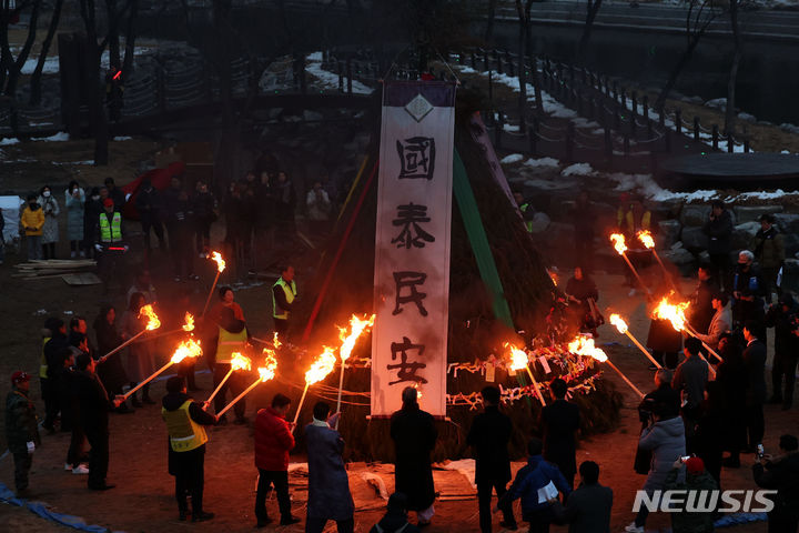 [서울=뉴시스] 김선웅 기자 = 정월대보름을 하루 앞둔 23일 서울 서초구 양재천에서 서초구 주최 정월대보름 축제가 열려 참석자들이 달집에 불을 붙이고 있다. 2024.02.23. mangusta@newsis.com