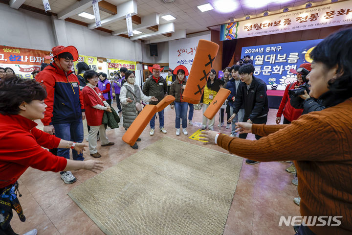 [서울=뉴시스] 정병혁 기자 = 24일 서울 동작구 2024 정월대보름 전통 문화행사를 찾은 시민들이 윷놀이를 하고 있다. 2024.02.24. jhope@newsis.com