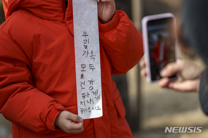 [서울=뉴시스] 정병혁 기자 = 정월대보름인 24일 서울 종로구 국립민속박물관을 찾은 어린이가 소원을 들어보이고 있다. 2024.02.24. jhope@newsis.com
