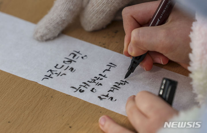 [서울=뉴시스] 정병혁 기자 = 정월대보름인 24일 서울 종로구 국립민속박물관을 찾은 시민들이 소원지에 소원을 적고 있다. 2024.02.24. jhope@newsis.com