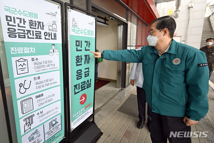 [서울=뉴시스] 청사사진기자단= 전공의 파업이 이어지는 25일 경기 성남시 국군수도병원 국군외상센터를 찾은 한덕수 국무총리가 석웅 국군수도병원장의 소개로 민간환자 응급진료 안내판을 보고 있다.2024.02.25. photo@newsis.com