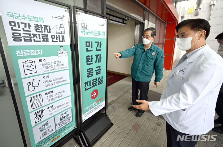 [서울=뉴시스] 청사사진기자단= 전공의 파업이 이어지는 25일 경기 성남시 국군수도병원 국군외상센터를 찾은 한덕수 국무총리가 석웅 국군수도병원장의 소개로 민간환자 응급진료 안내판을 보고 있다.2024.02.25. photo@newsis.com